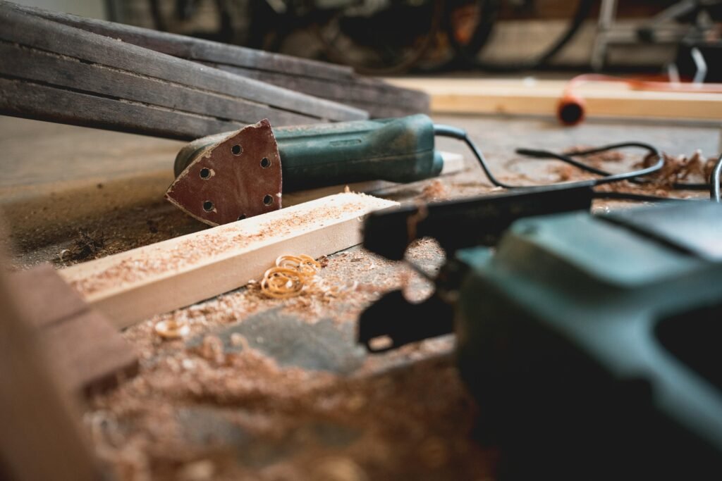 pexels-photo-1094770-1094770 Close-up of various woodworking tools in a workshop, featuring wood shavings and equipment.